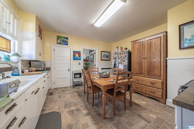 dining room with heating unit, sink, and a healthy amount of sunlight