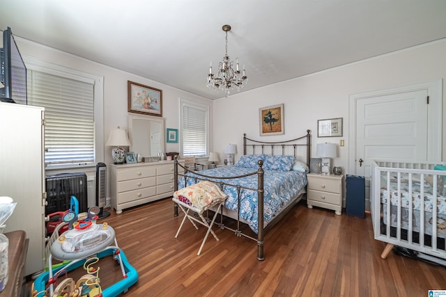 bedroom featuring dark wood-type flooring and an inviting chandelier