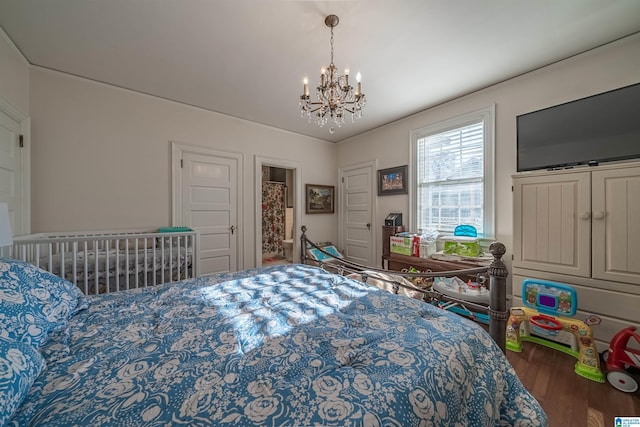 bedroom with ornamental molding, dark hardwood / wood-style floors, and an inviting chandelier