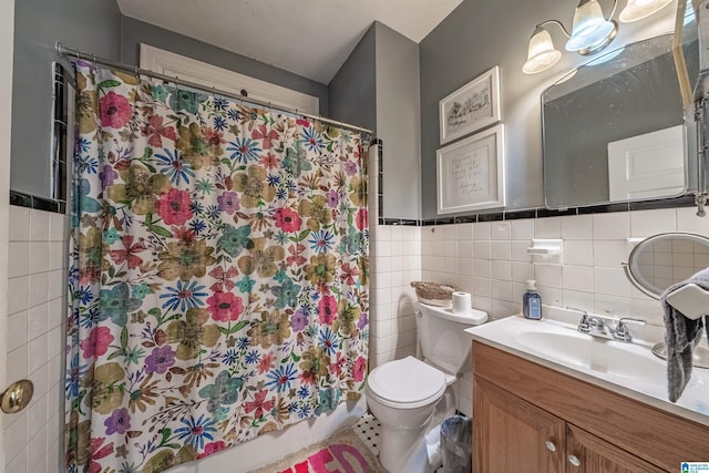 bathroom featuring vanity, toilet, and tile walls