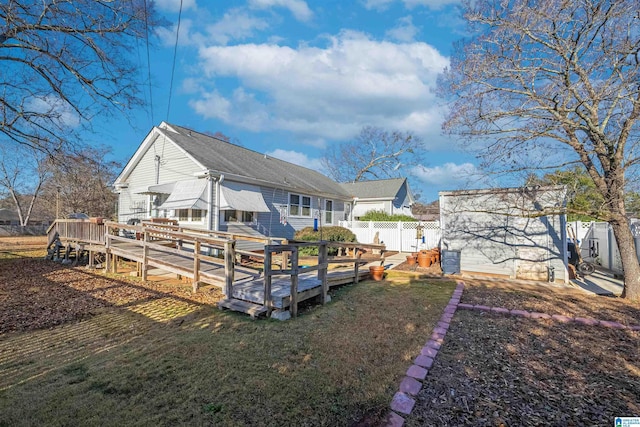 rear view of house with a yard and a deck