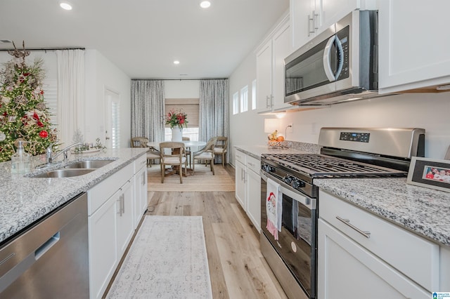 kitchen featuring white cabinets, light stone countertops, and stainless steel appliances