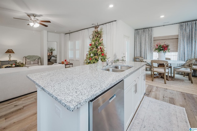 kitchen featuring white cabinets, sink, stainless steel dishwasher, light wood-type flooring, and a healthy amount of sunlight