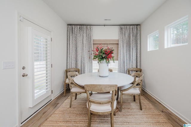 dining space featuring hardwood / wood-style floors and a healthy amount of sunlight