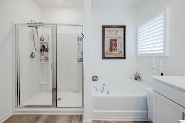 bathroom with hardwood / wood-style flooring, vanity, and independent shower and bath