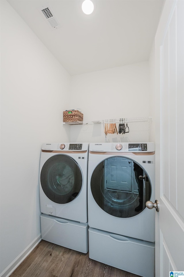 clothes washing area featuring dark hardwood / wood-style flooring and separate washer and dryer