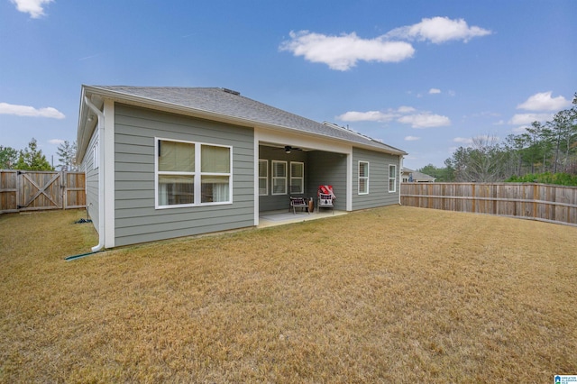 rear view of property with a lawn, ceiling fan, and a patio