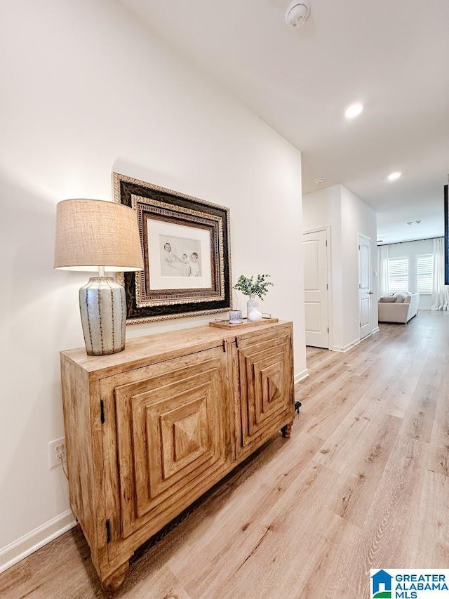 hall featuring light wood-style floors, recessed lighting, and baseboards