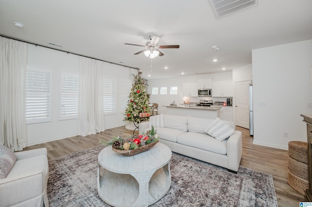 living room featuring light wood-type flooring and ceiling fan