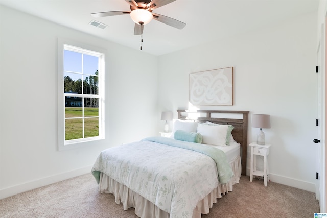 carpeted bedroom featuring ceiling fan and multiple windows