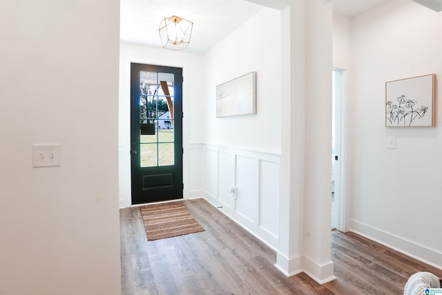 foyer entrance with light hardwood / wood-style floors and a notable chandelier