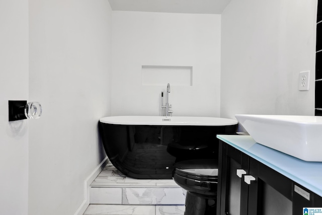 bathroom with a tub, vanity, and toilet