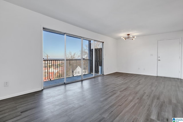 unfurnished room with hardwood / wood-style floors and a notable chandelier