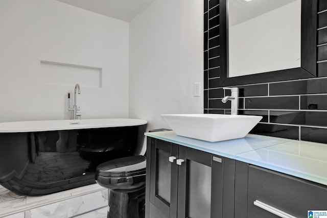 bathroom with vanity, tasteful backsplash, and toilet