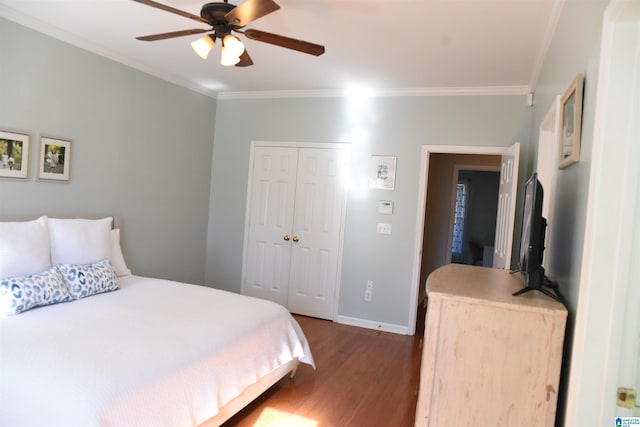 bedroom featuring ceiling fan, a closet, crown molding, and dark wood-type flooring