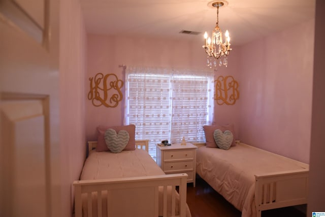 bedroom featuring hardwood / wood-style floors and a notable chandelier