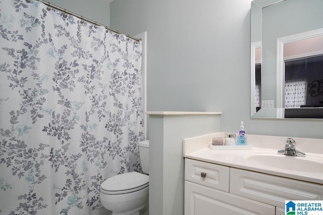 bathroom with vanity, toilet, and curtained shower