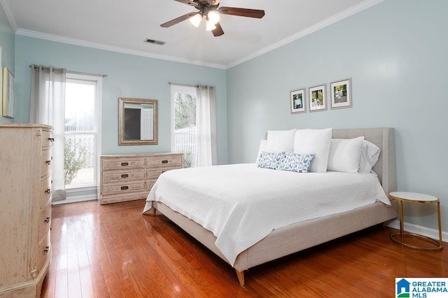 bedroom featuring hardwood / wood-style floors, ceiling fan, and ornamental molding