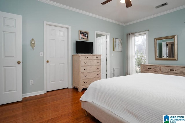 bedroom featuring hardwood / wood-style flooring, ceiling fan, and crown molding