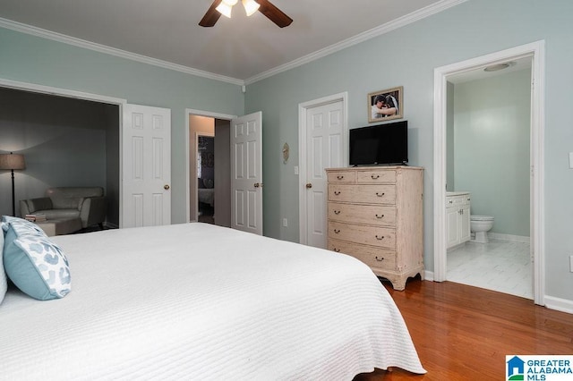 bedroom featuring hardwood / wood-style flooring, ensuite bathroom, ceiling fan, and crown molding