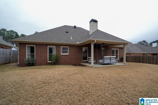 back of house featuring an outdoor living space, a patio area, and a yard