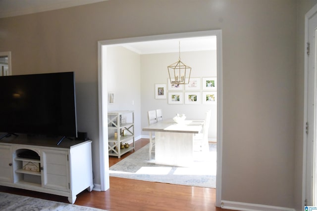 living room featuring ornamental molding, a chandelier, and hardwood / wood-style flooring