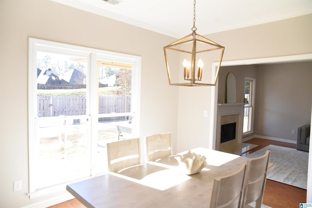 dining area featuring a notable chandelier, wood-type flooring, and ornamental molding