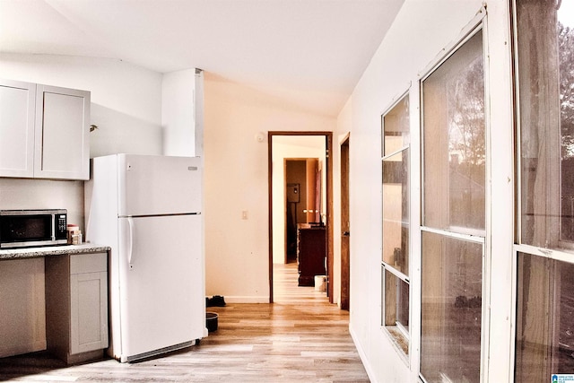 kitchen featuring gray cabinetry, white refrigerator, light wood-type flooring, and vaulted ceiling