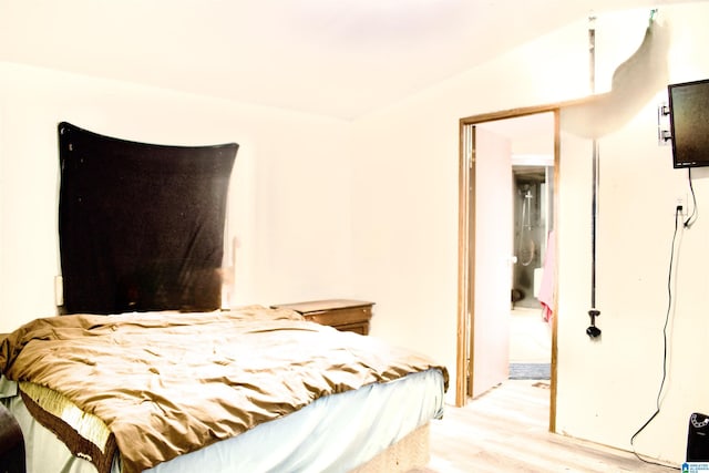 bedroom featuring a closet, light hardwood / wood-style floors, and lofted ceiling