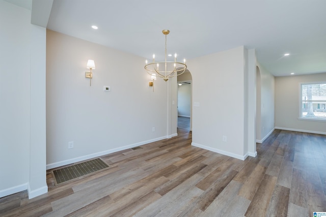 unfurnished room featuring light wood-type flooring and a chandelier