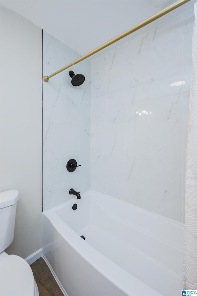 bathroom with shower / bath combo with shower curtain, hardwood / wood-style floors, and toilet