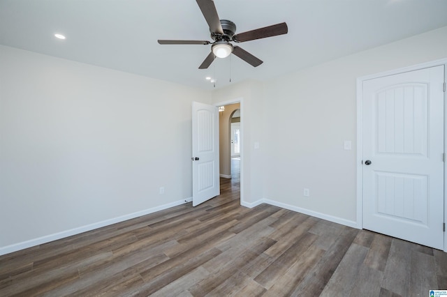 unfurnished room with ceiling fan and dark hardwood / wood-style flooring