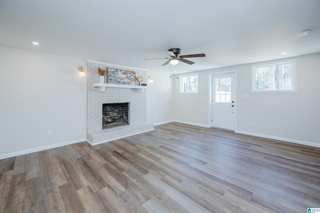 unfurnished living room with a fireplace, light hardwood / wood-style flooring, and ceiling fan