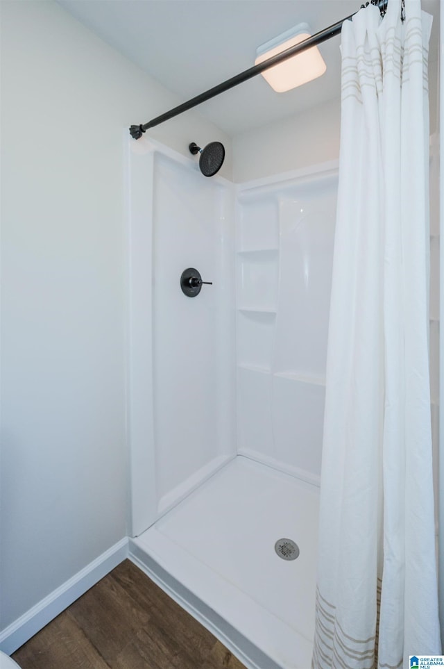 bathroom with curtained shower and wood-type flooring