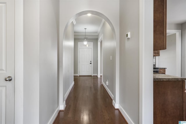 hallway with dark hardwood / wood-style floors and ornamental molding