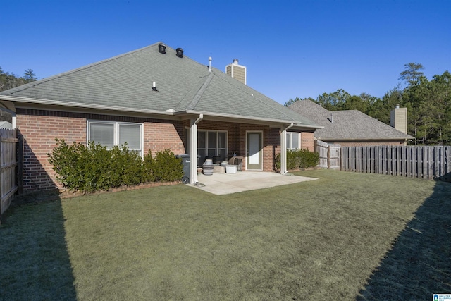 rear view of property with a lawn and a patio area