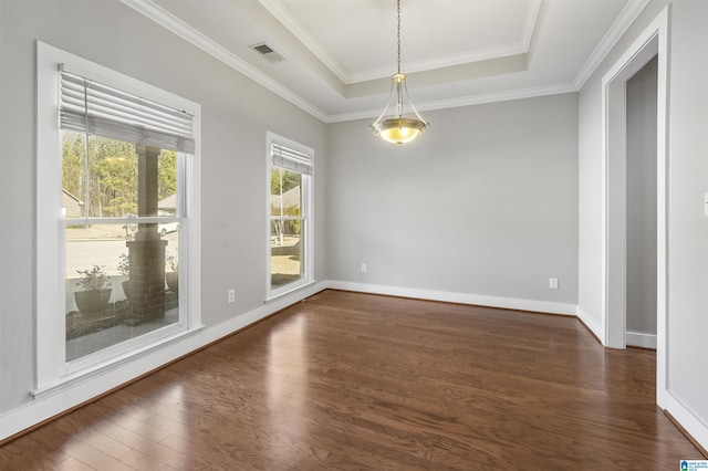 spare room featuring dark hardwood / wood-style floors, a raised ceiling, and ornamental molding