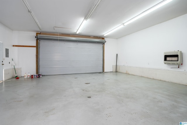 garage featuring electric panel and heating unit