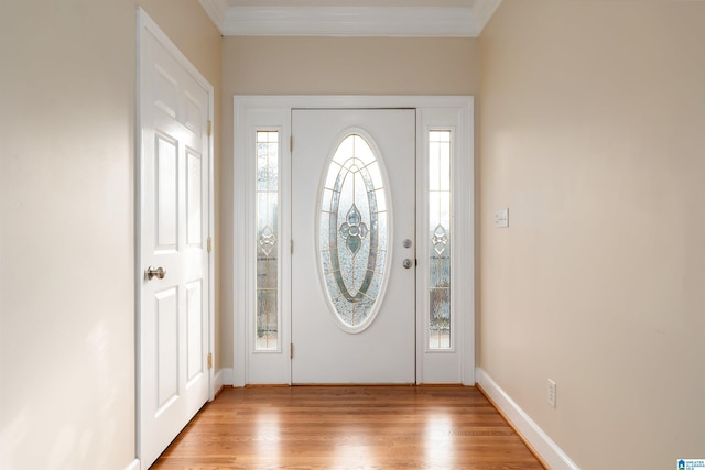 foyer entrance with light wood-type flooring and ornamental molding