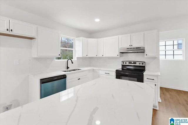 kitchen with white cabinets, sink, light hardwood / wood-style flooring, light stone countertops, and appliances with stainless steel finishes