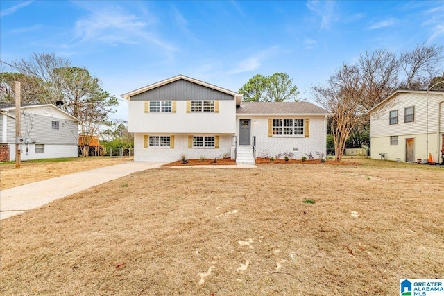 tri-level home with a front lawn