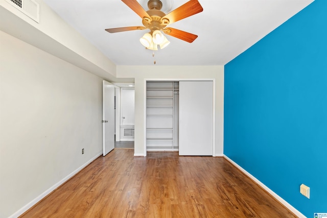 unfurnished bedroom featuring wood-type flooring, a closet, and ceiling fan