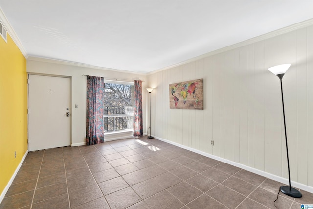 spare room with dark tile patterned floors and ornamental molding