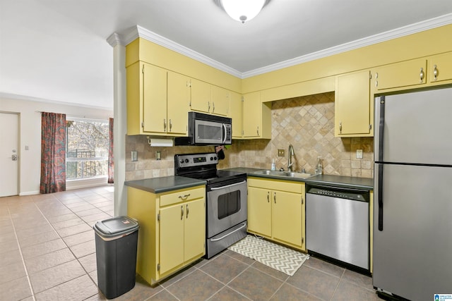 kitchen with backsplash, crown molding, sink, and stainless steel appliances