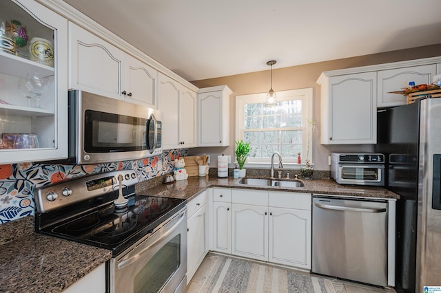 kitchen with appliances with stainless steel finishes, white cabinetry, and sink