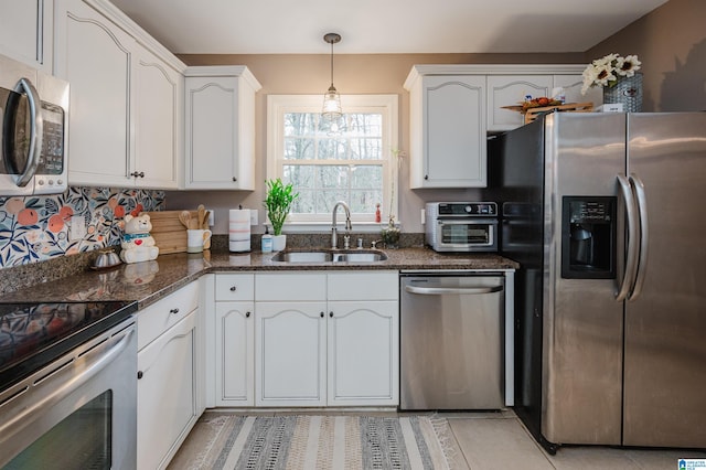 kitchen featuring stainless steel appliances, white cabinetry, and sink