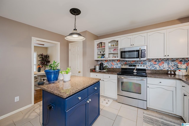 kitchen featuring tasteful backsplash, stainless steel appliances, blue cabinets, white cabinets, and light tile patterned flooring