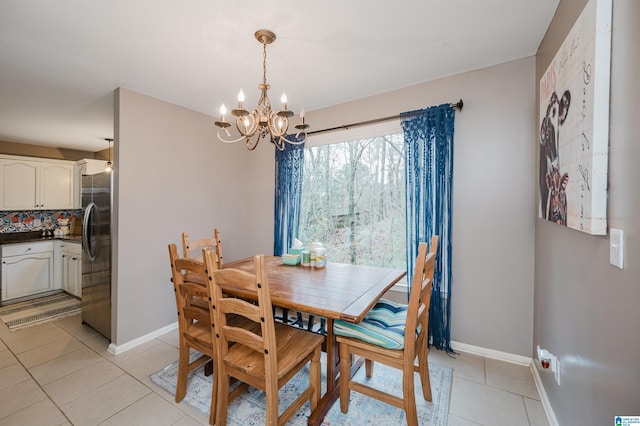 dining space with light tile patterned floors and an inviting chandelier