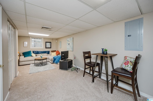 living room featuring carpet flooring, electric panel, and a drop ceiling