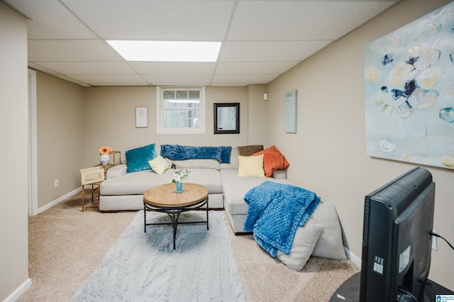 carpeted living room featuring a drop ceiling